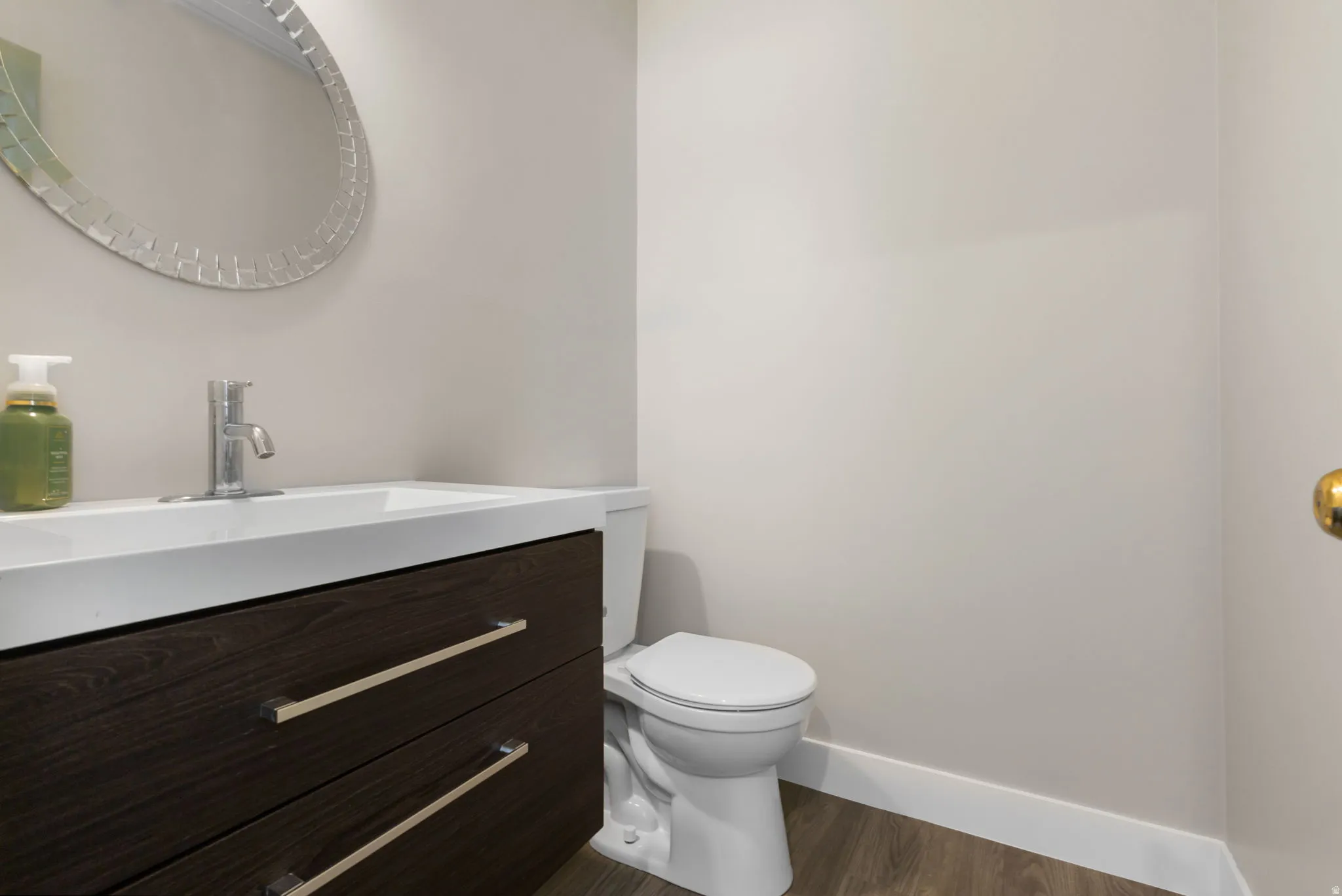 Powder bathroom off the mudroom and back door. Modern vanity with dark wood-finish cabinetry and chrome hardware