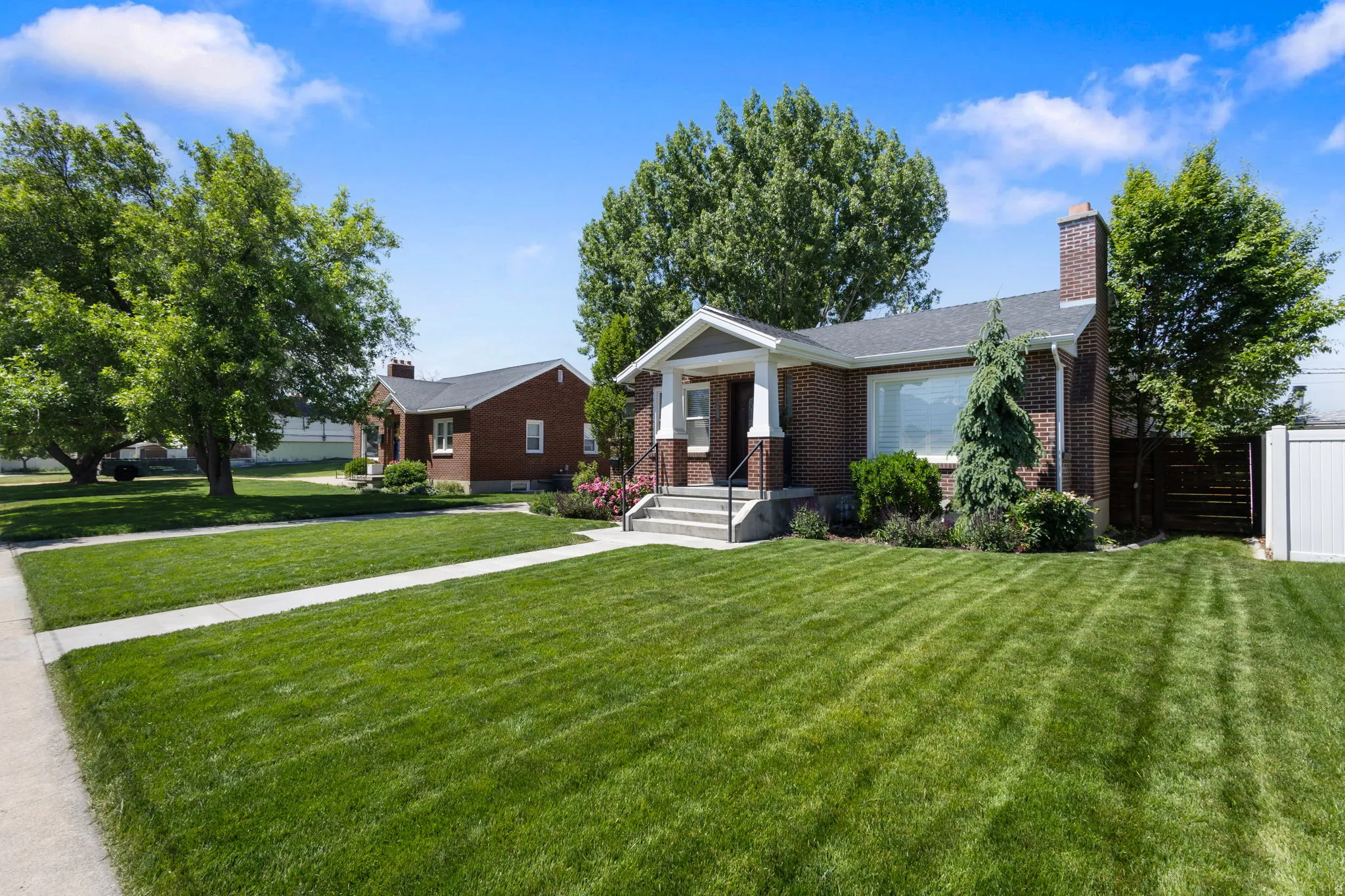 Brick exterior featuring a covered porch, white columns, and a prominent brick chimney