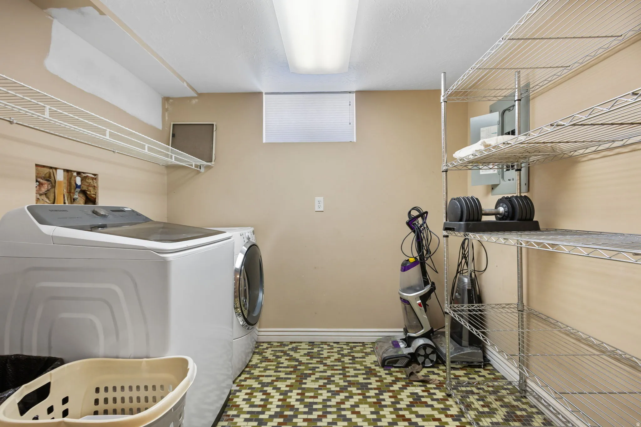 Laundry area featuring a window, built-in shelving, tiled flooring, and appliances