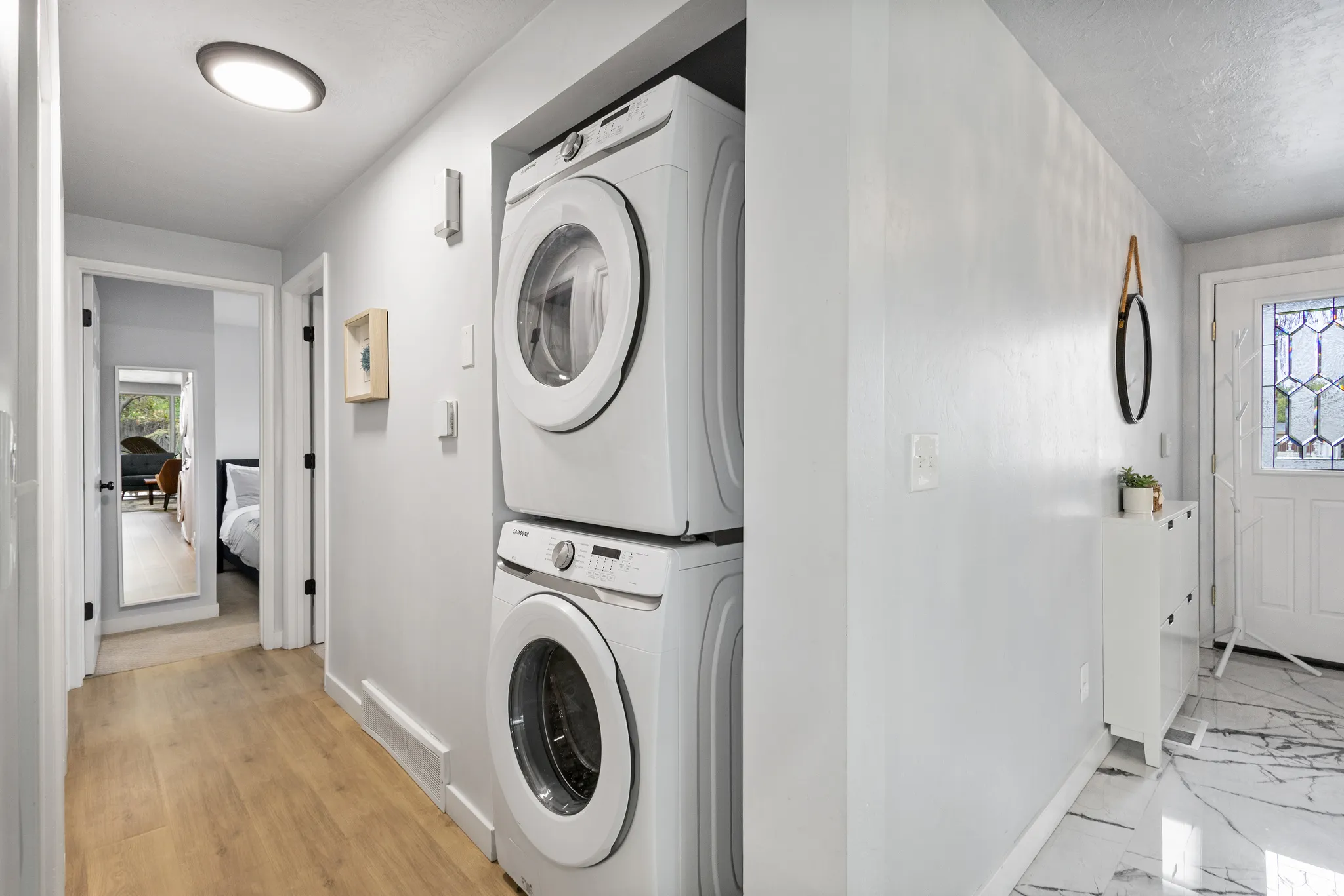 Integrated laundry area featuring stacked front-loading appliances