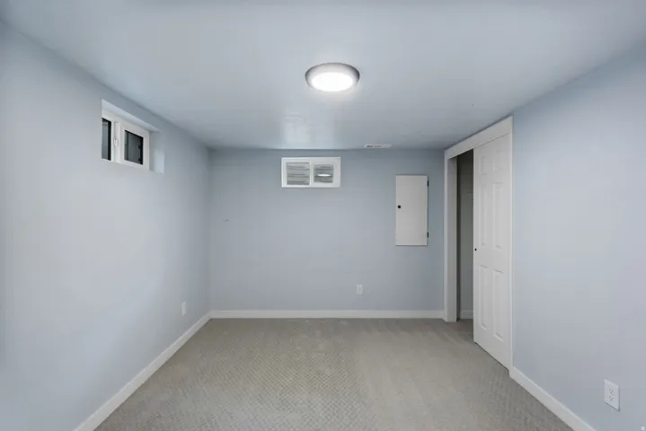 Spacious room with light gray carpeting, neutral wall color, and a flush-mount ceiling light