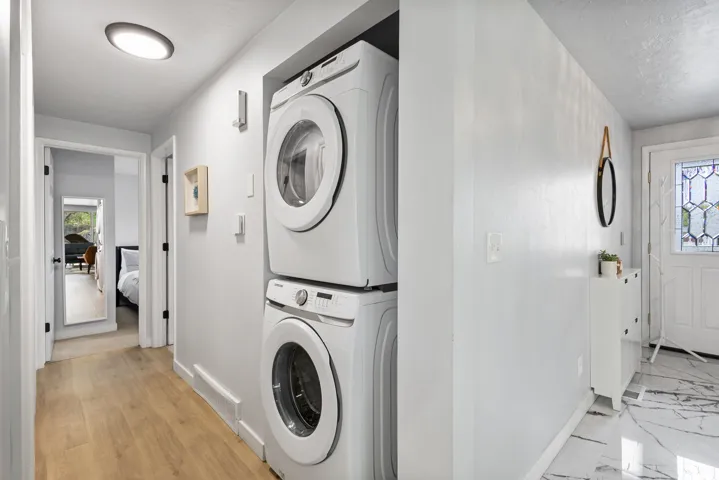 Integrated laundry area featuring stacked front-loading appliances