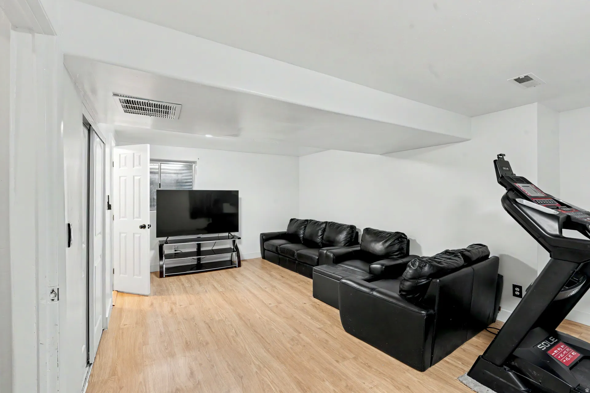 2nd Spacious living room featuring wood-finish flooring and white painted walls