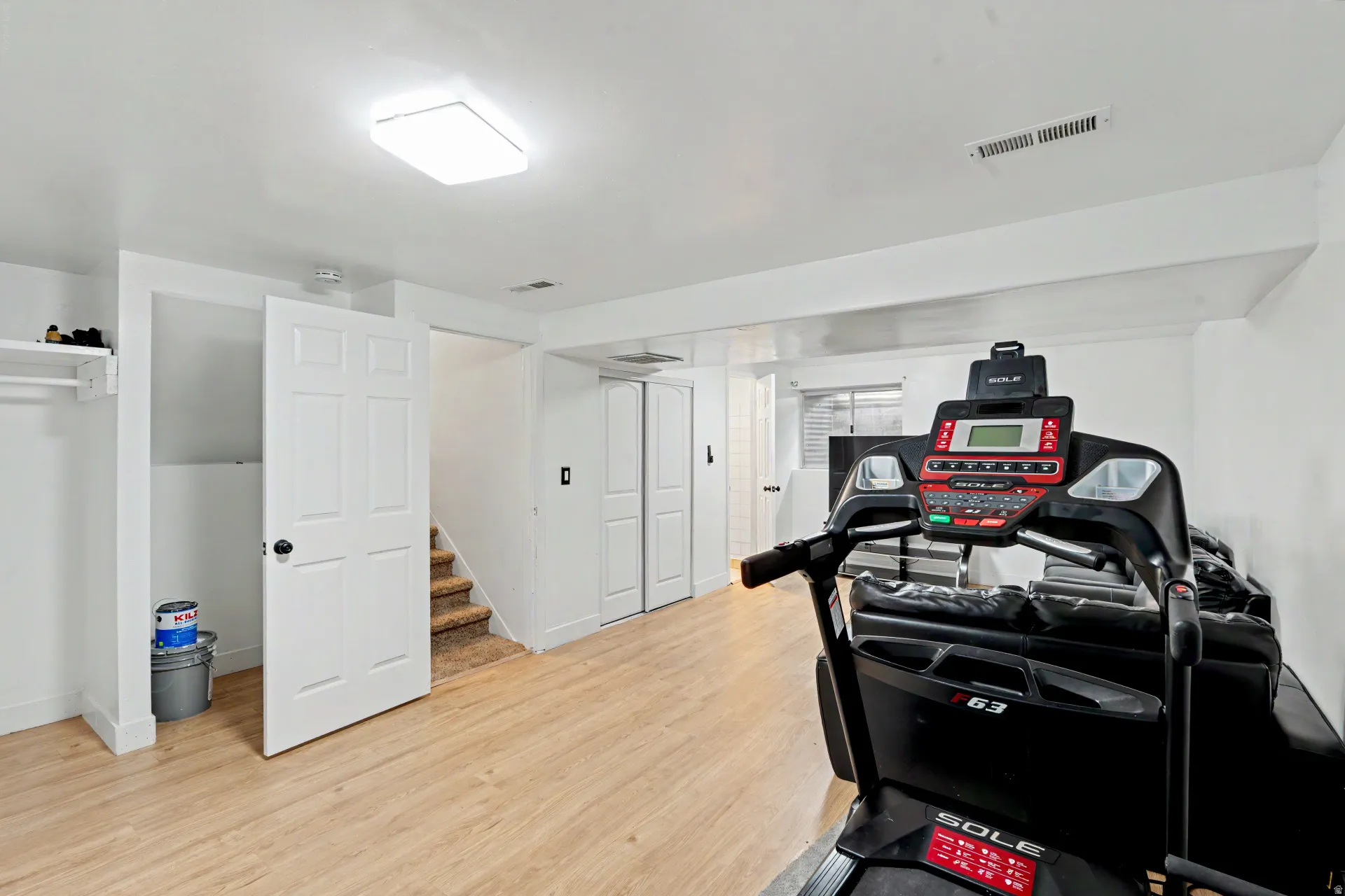 Finished lower level offering wood-finish flooring, recessed lighting, white trim, and a storage closet with bi-fold doors