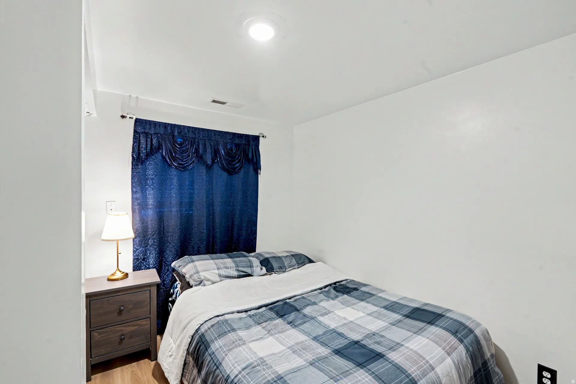 3rd Bedroom downstairs with recessed ceiling lighting, wood-finish flooring, and a window featuring window treatments