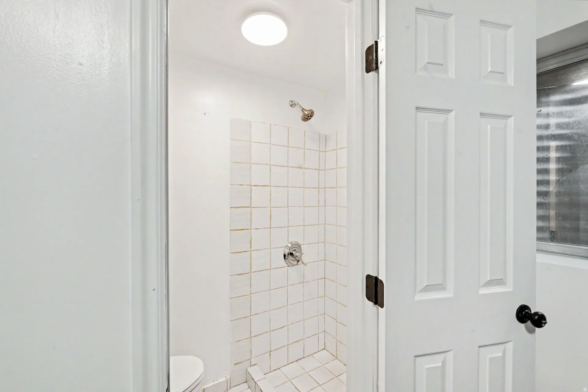 3rd bathroom with Shower enclosure featuring white square tile, chrome fixtures, and a ceiling-mounted light