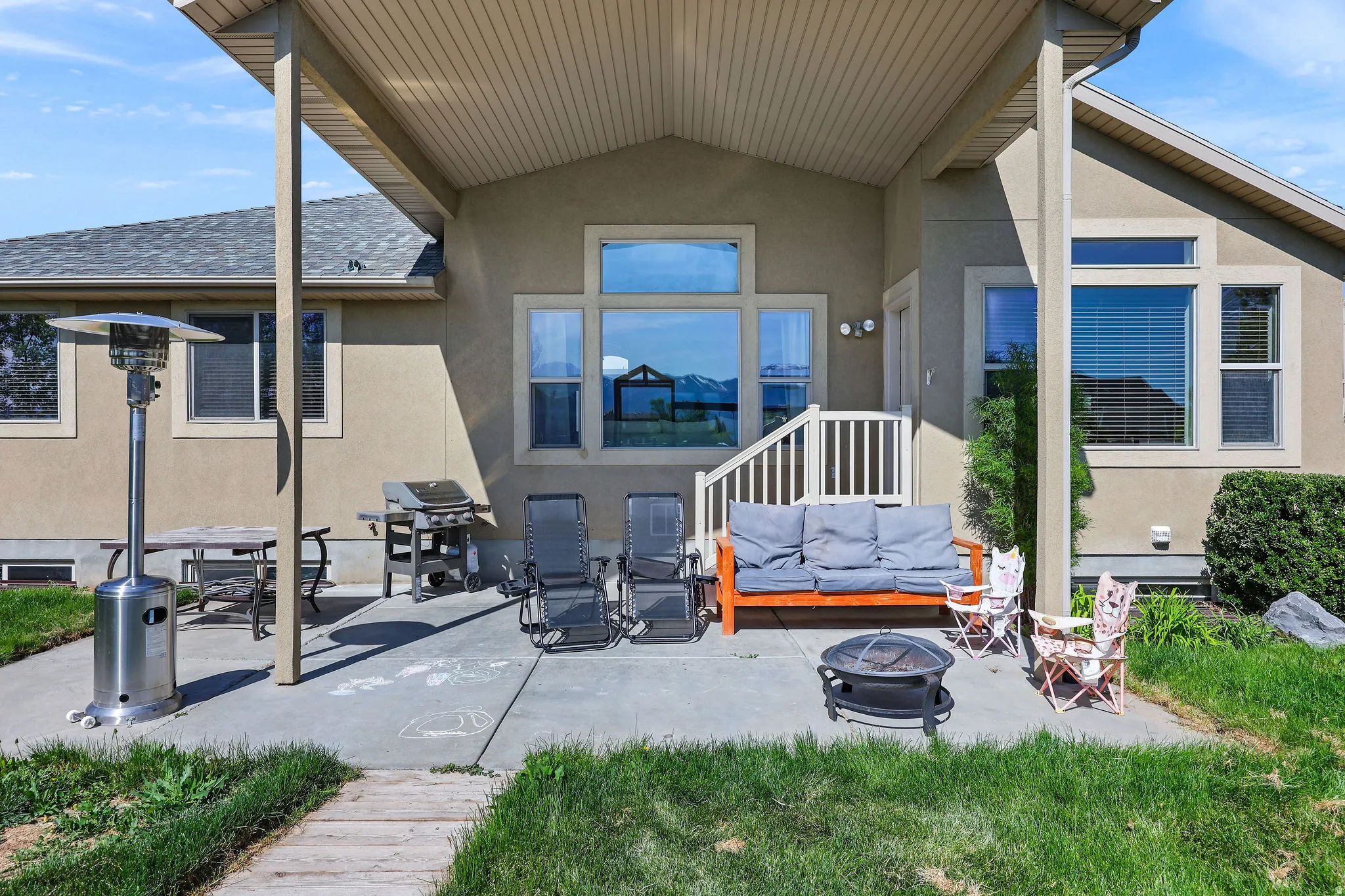 Covered concrete patio with stucco exterior and white railing