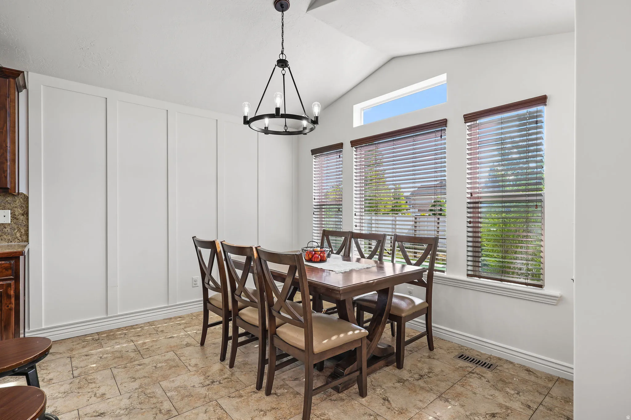 Dining area featuring a vaulted ceiling and a contemporary chandelier