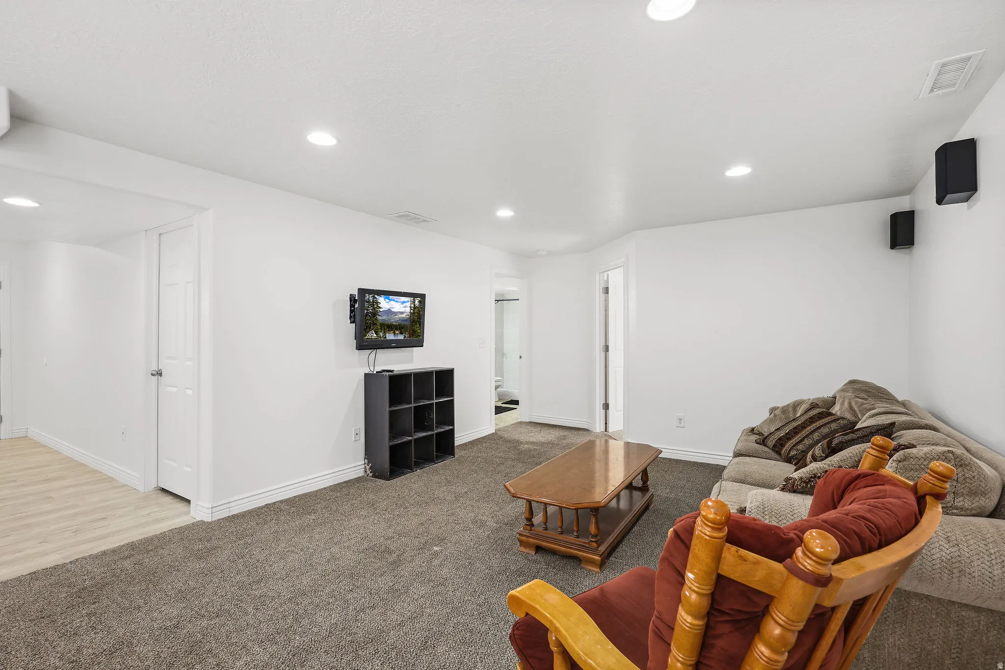 Spacious room with recessed lighting and neutral gray carpet