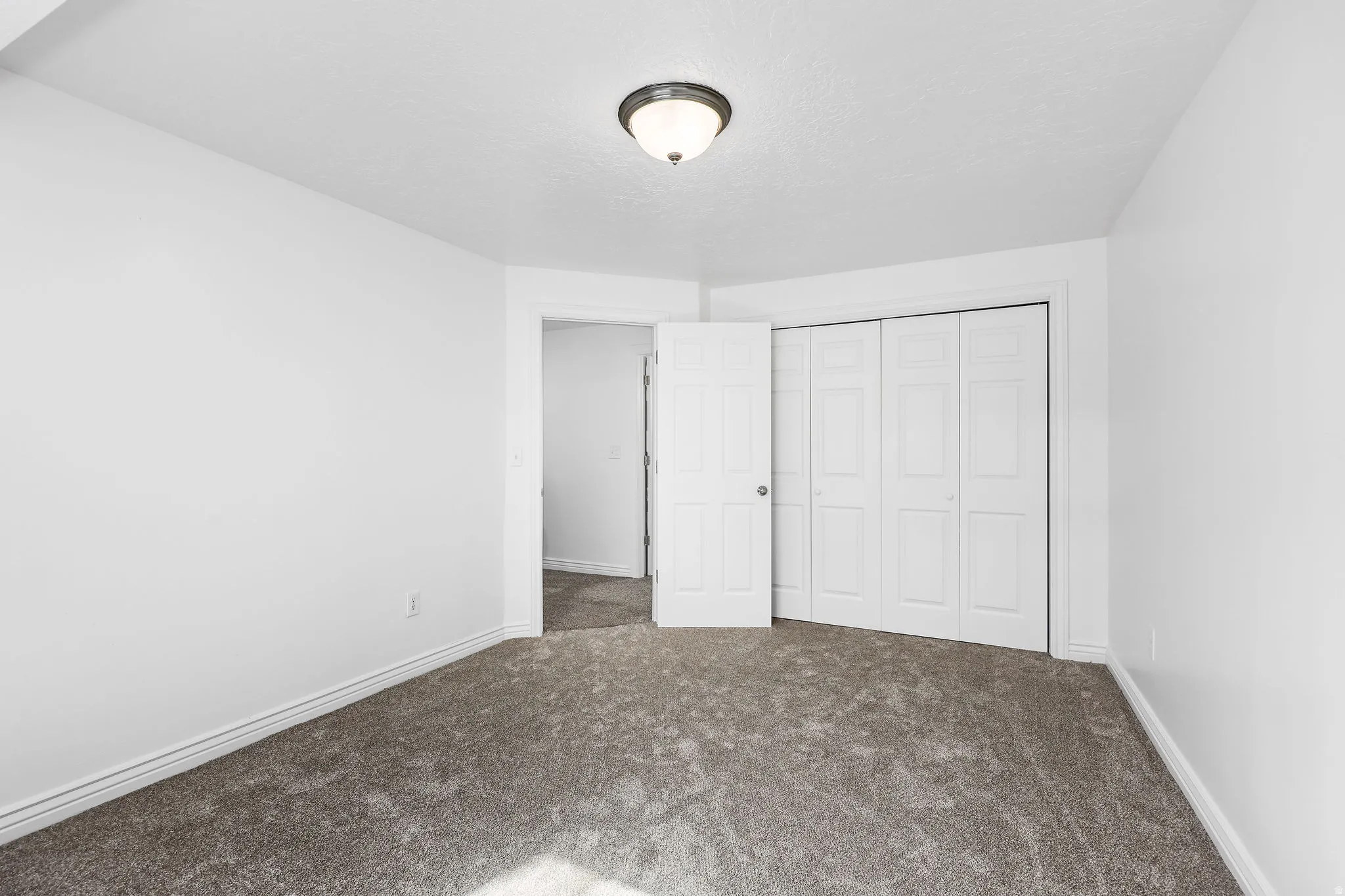 Carpeted interior space featuring white walls and baseboards