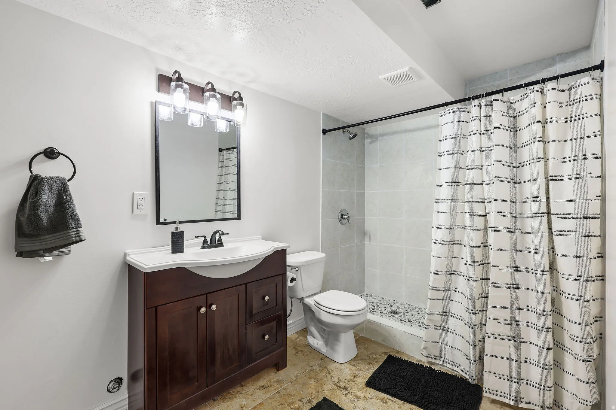 Bathroom featuring a dark wood-finish vanity with a white countertop and integrated sink