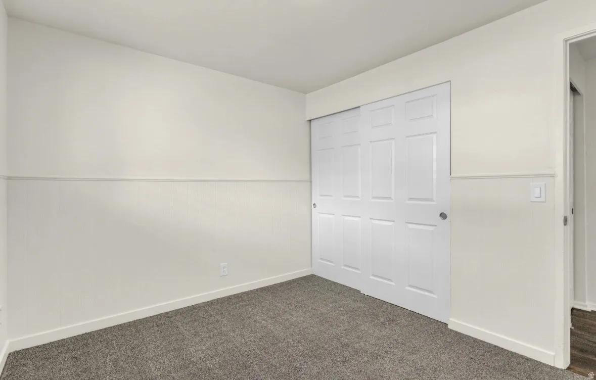 Interior space featuring light gray carpet flooring and white baseboards