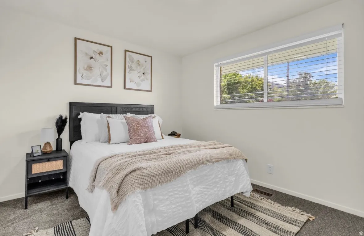 Light-toned walls complement the dark textured headboard