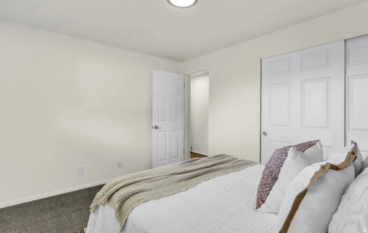 Bedroom featuring light-toned walls, recessed lighting, and dark carpet flooring