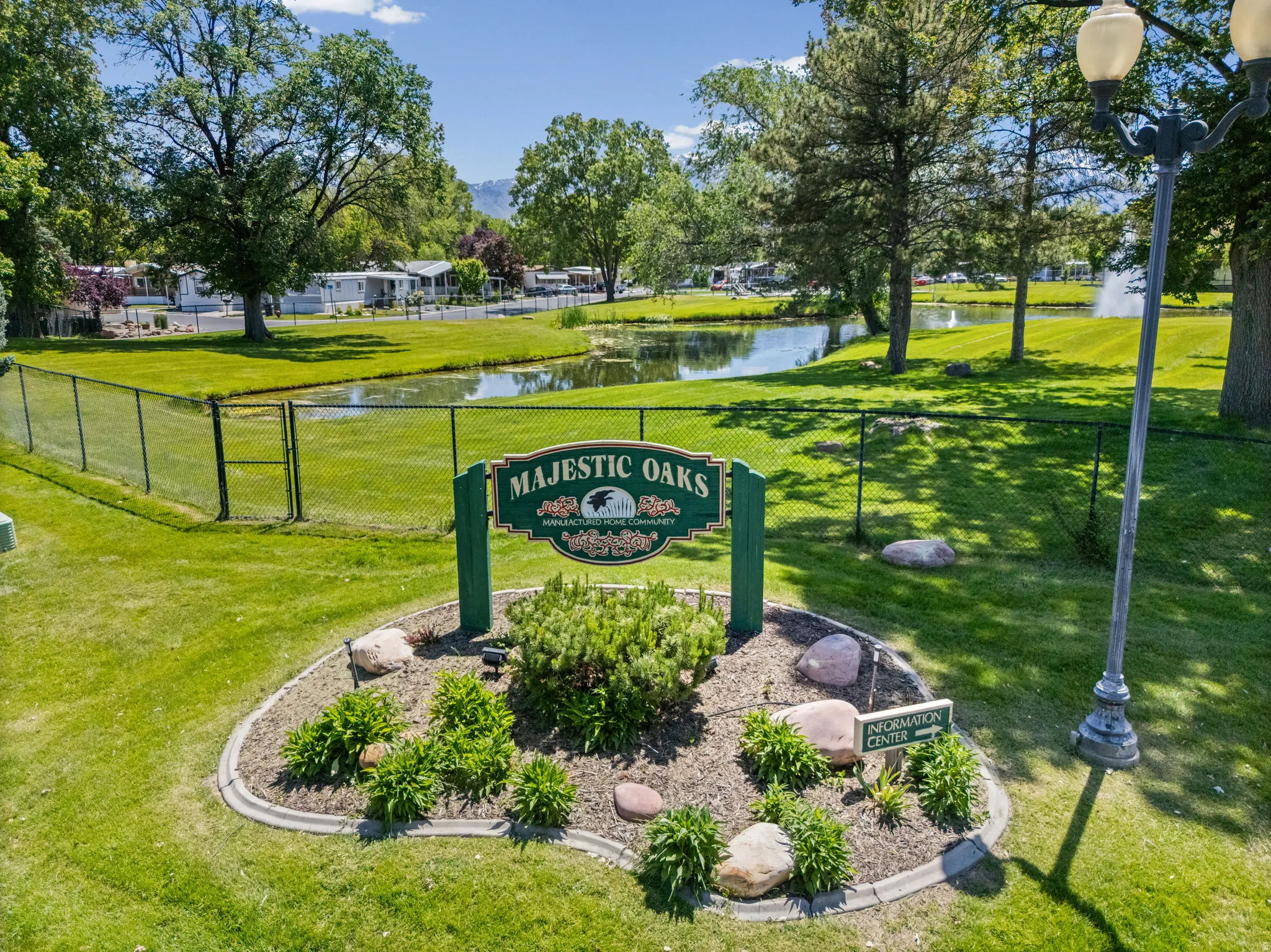 "Majestic Oaks" community entrance sign framed by a landscaped garden bed with decorative rocks and plantings