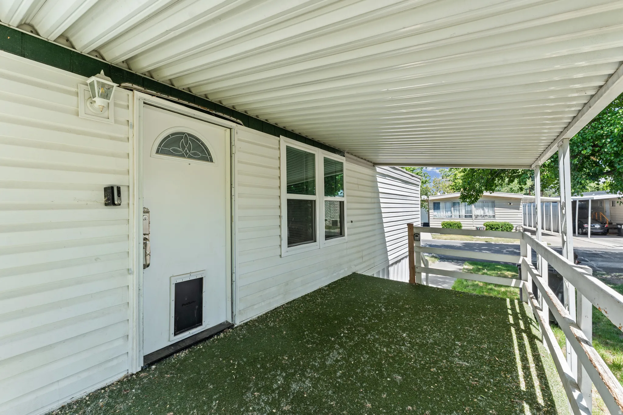 Covered front porch featuring white vinyl siding