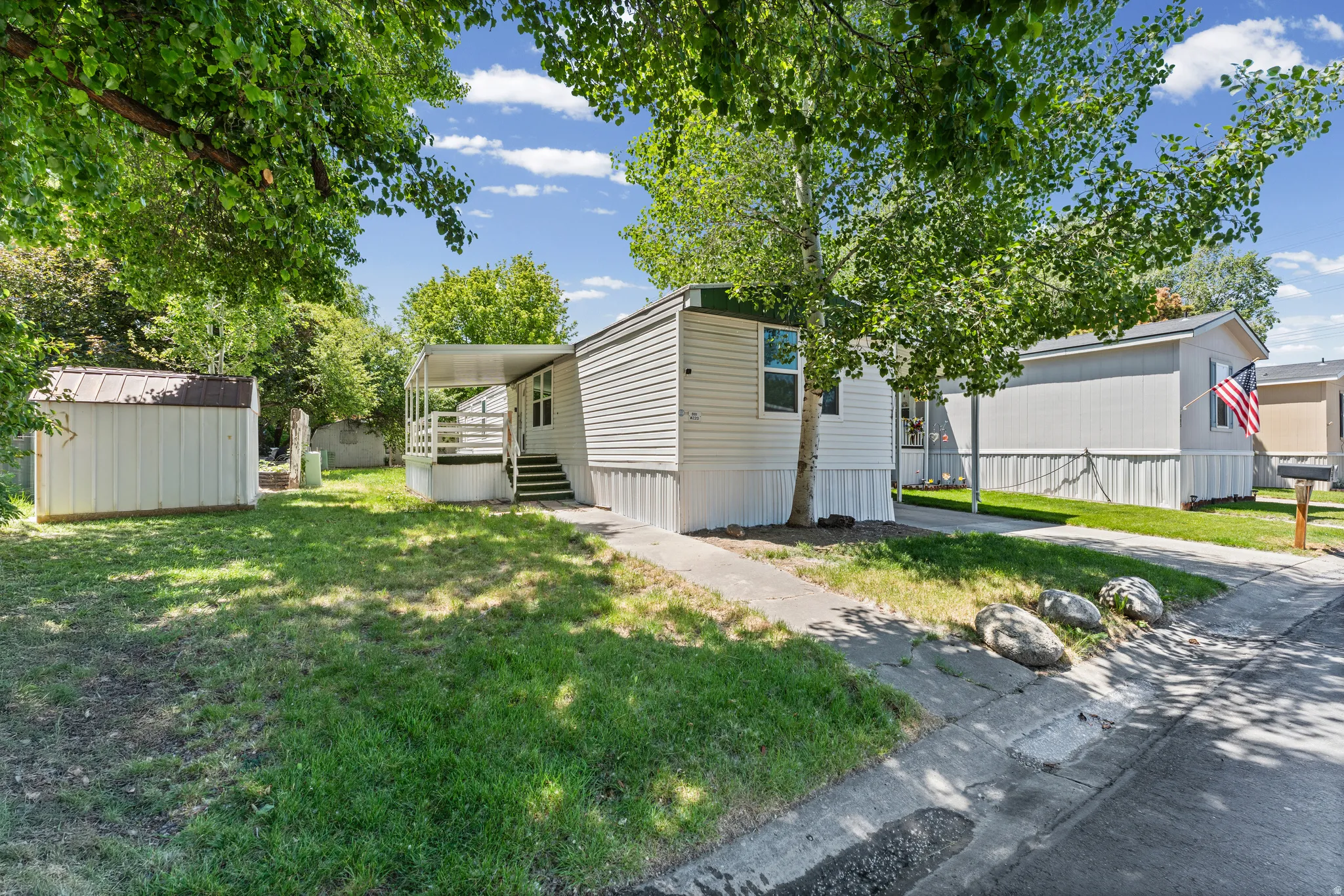 White siding exterior with a covered porch and an exterior storage shed