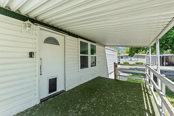 Covered front porch featuring white vinyl siding