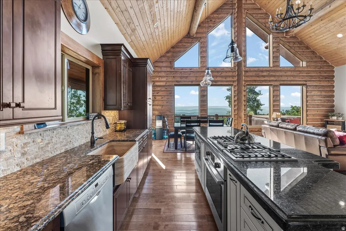 Kitchen featuring wood-finish flooring, granite countertops, and dark wood cabinetry