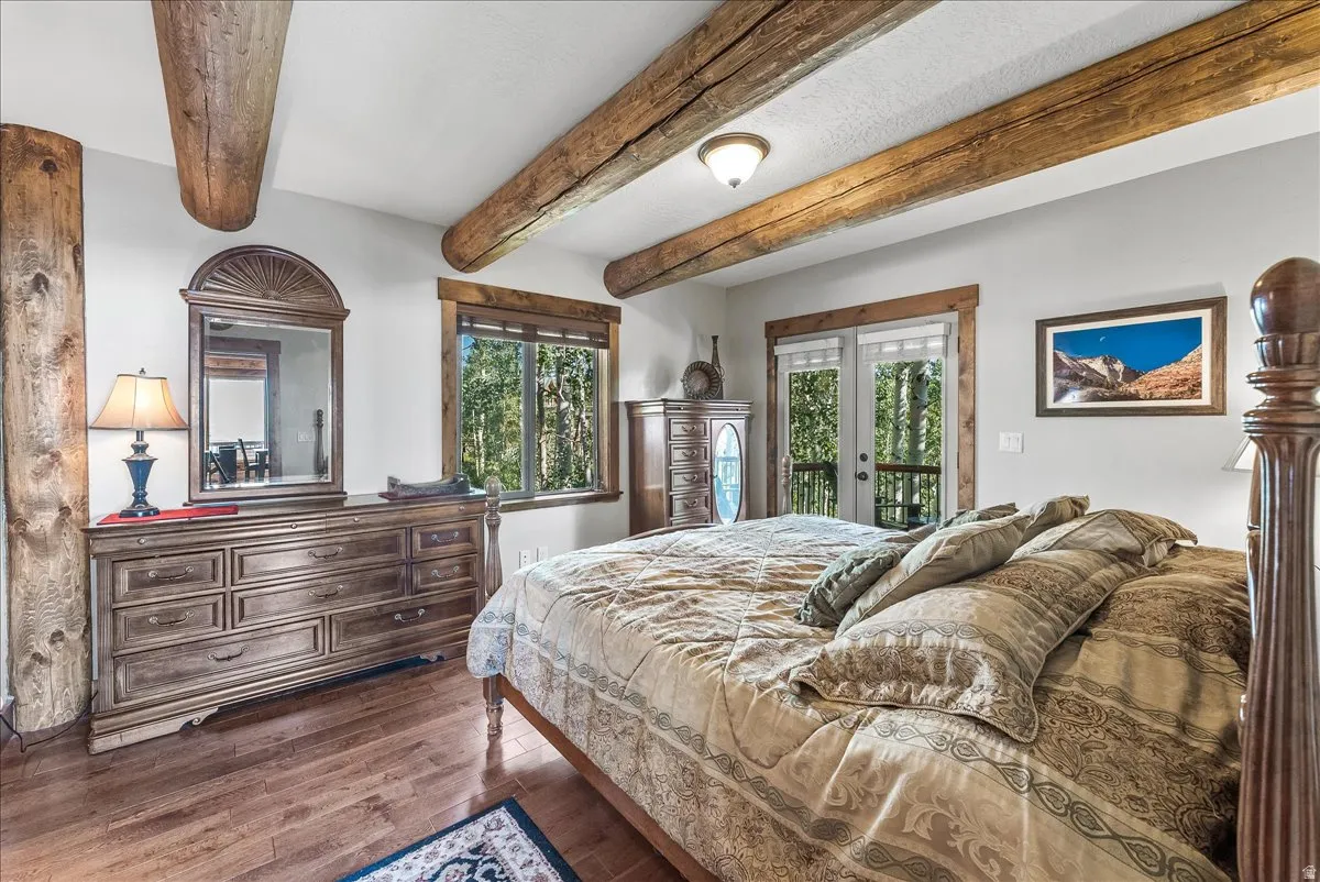 Spacious room featuring exposed wood ceiling beams and wood-finish flooring