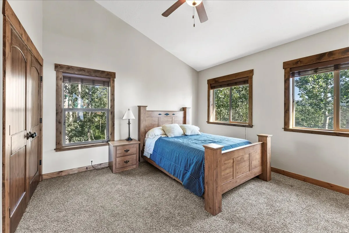 Spacious room featuring vaulted ceilings, light-toned walls, and plush carpeting