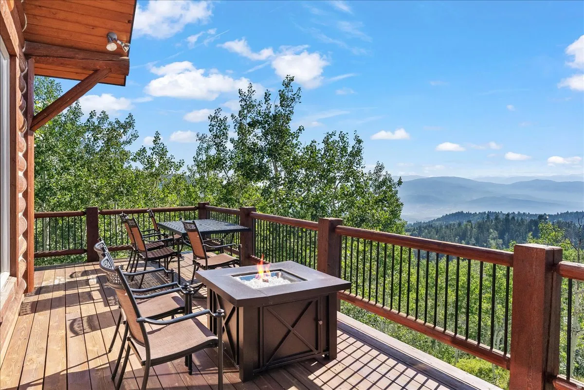 Expansive wood deck with a built-in fire pit and wood railings