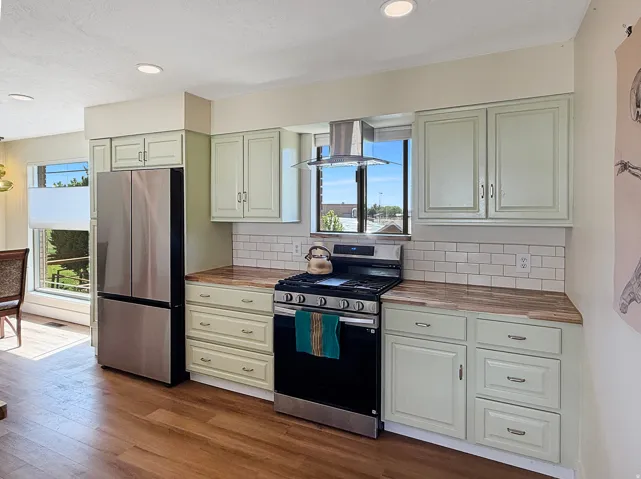 Kitchen featuring wood-finish flooring, recessed lighting, and a stainless steel refrigerator