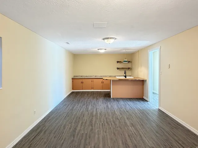 Spacious room featuring wood-finish flooring and neutral wall tones