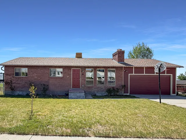 Brick exterior featuring a red entry door and a one-car garage