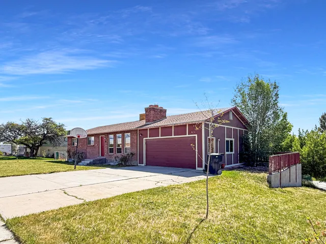 Ranch-style exterior with brick and vertical siding accents, featuring a two-car garage