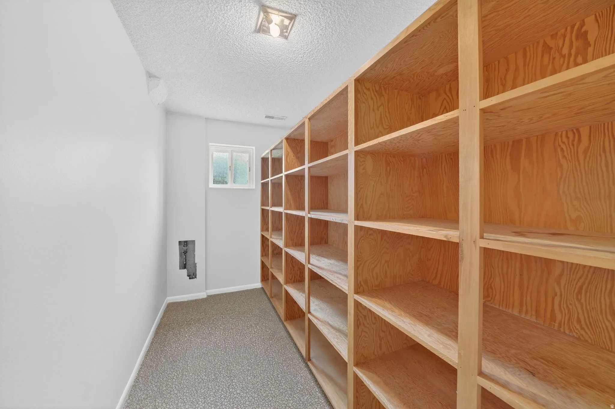 Extensive built-in wood shelving provides ample storage. Could easily be converted into a galley style kitchen