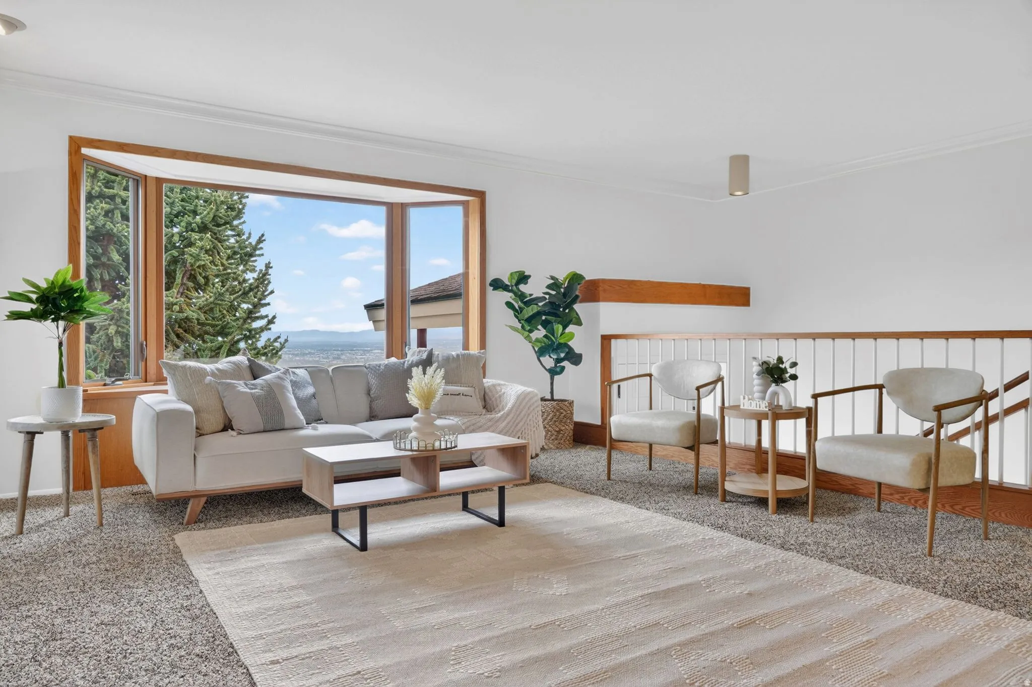 Bright living area featuring a large bay window with natural wood trim, plush carpeting, and crown molding