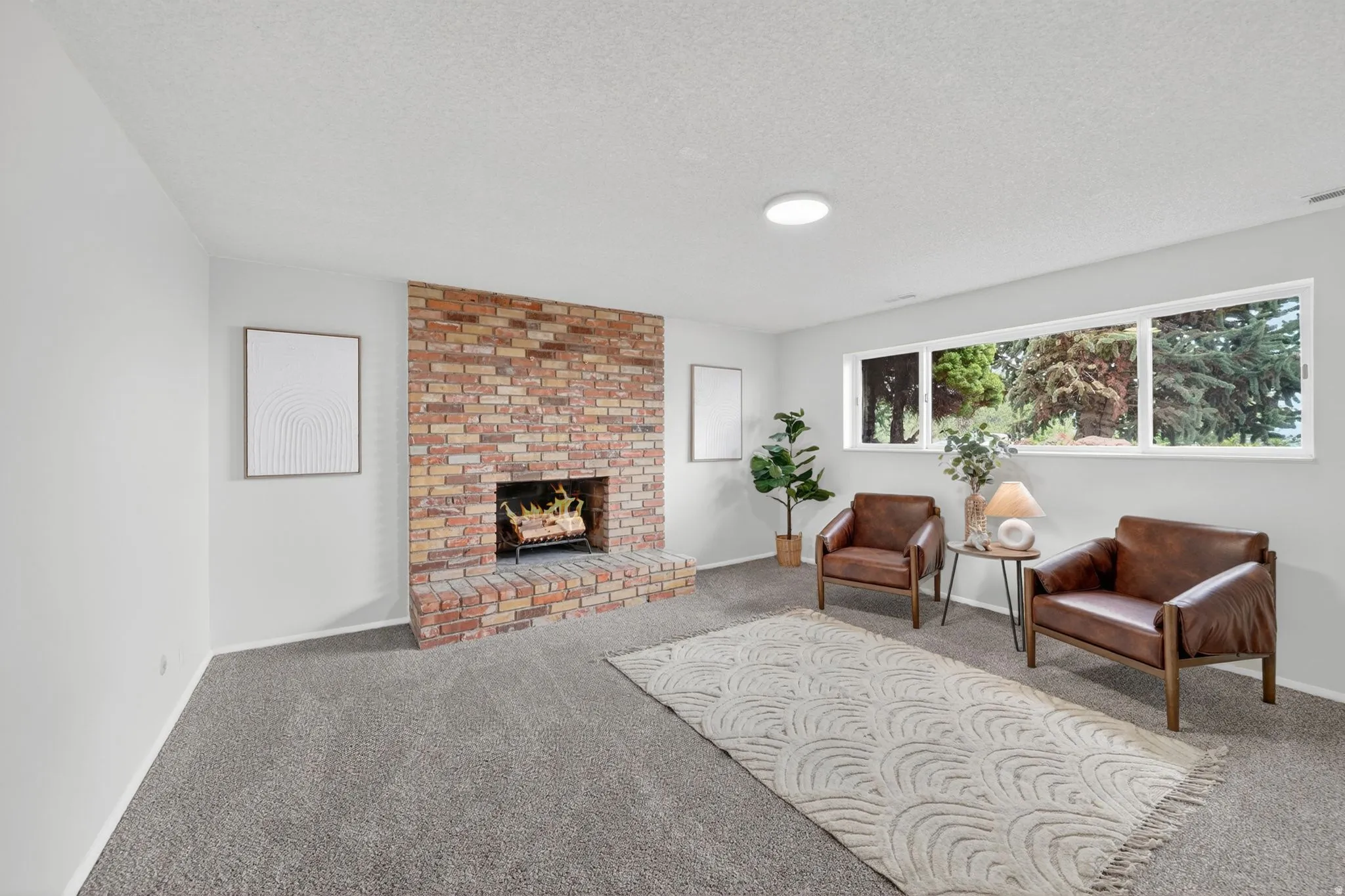 Spacious living room featuring a brick fireplace with a hearth, and lots of natural light