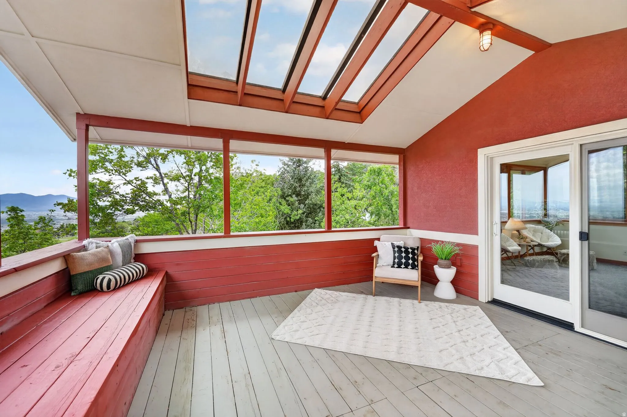 Spacious covered deck featuring a built-in bench, skylights, and a sliding glass door