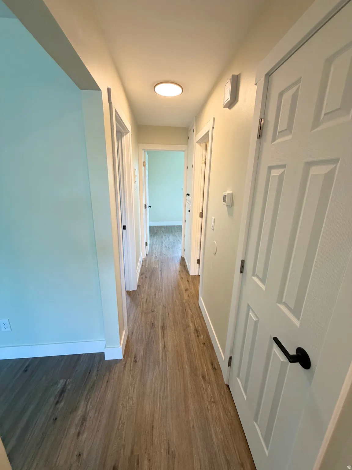 Hallway with wood-finish flooring extending throughout