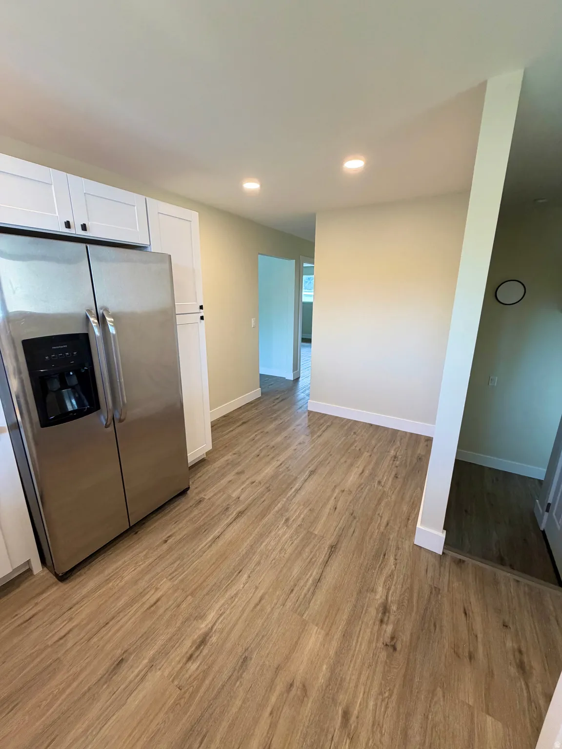 Open-concept space featuring wood-finish flooring, recessed lighting, and a stainless steel side-by-side refrigerator