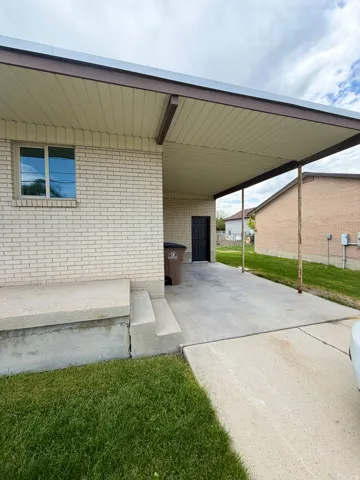 Carport with a light-colored soffit and brown trim, providing covered parking