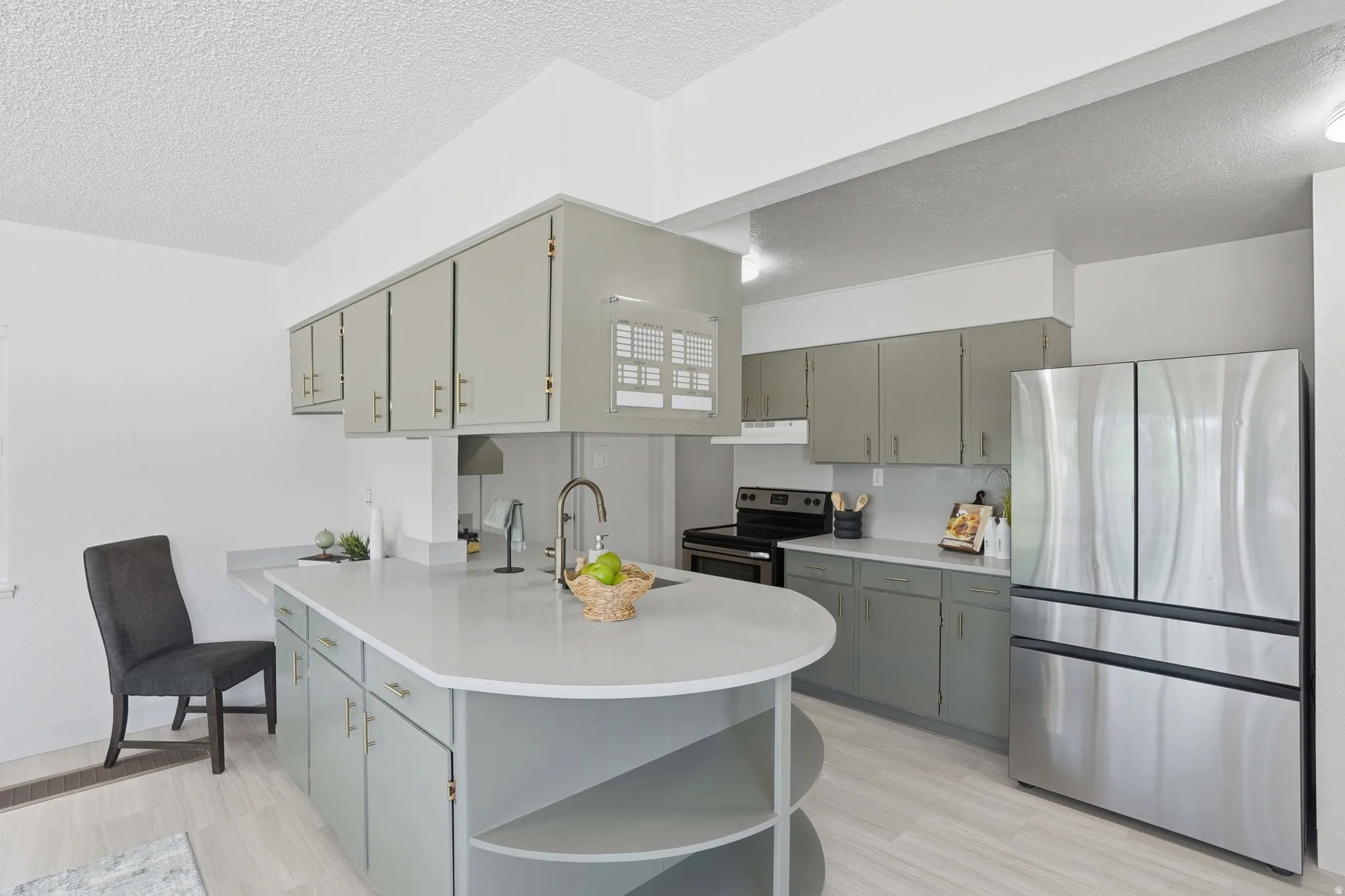 Modern kitchen featuring an expansive central island with an integrated sink and gooseneck faucet