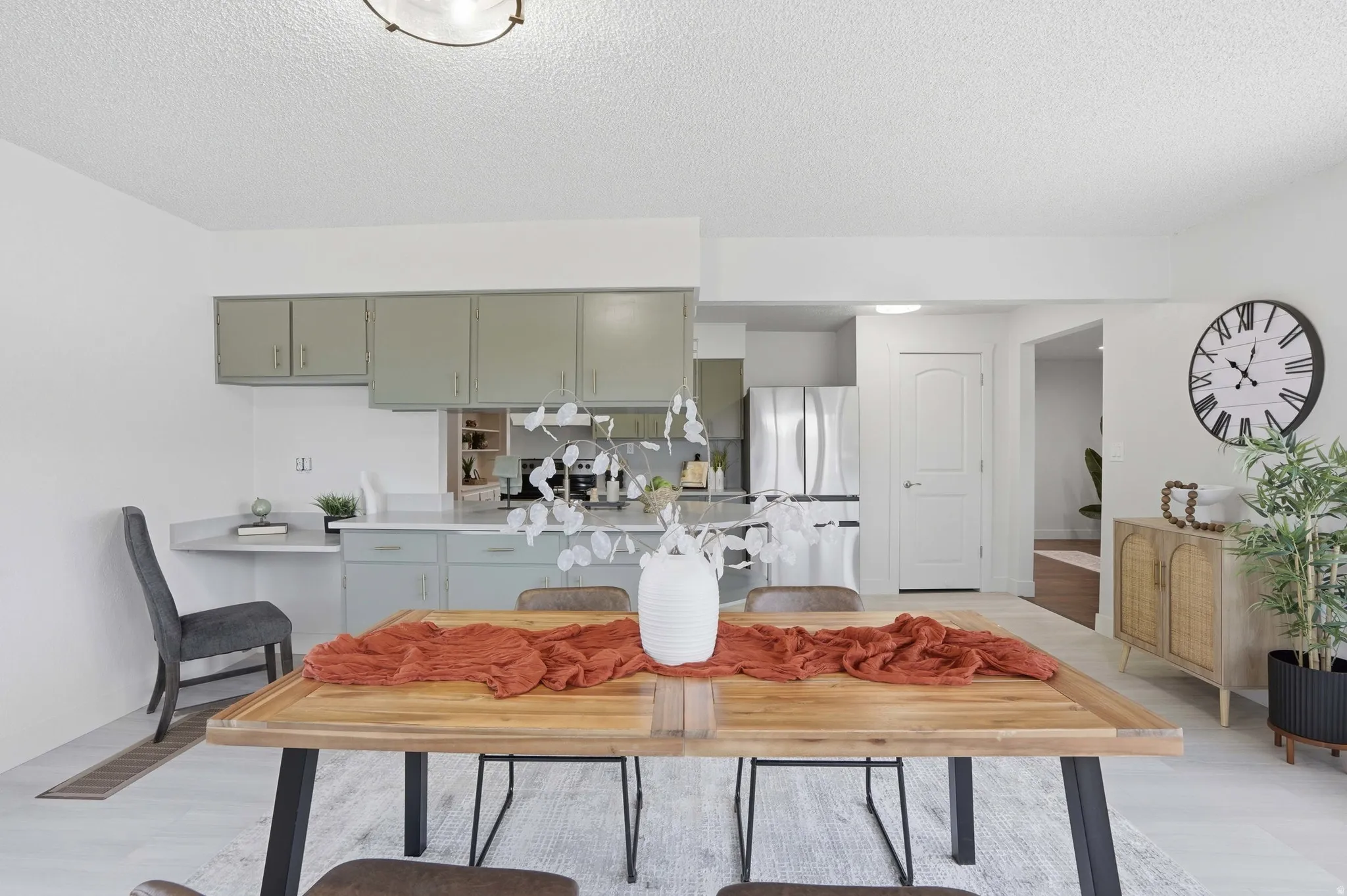 Dining area with light wood-finish flooring featuring an open-concept design to the kitchen