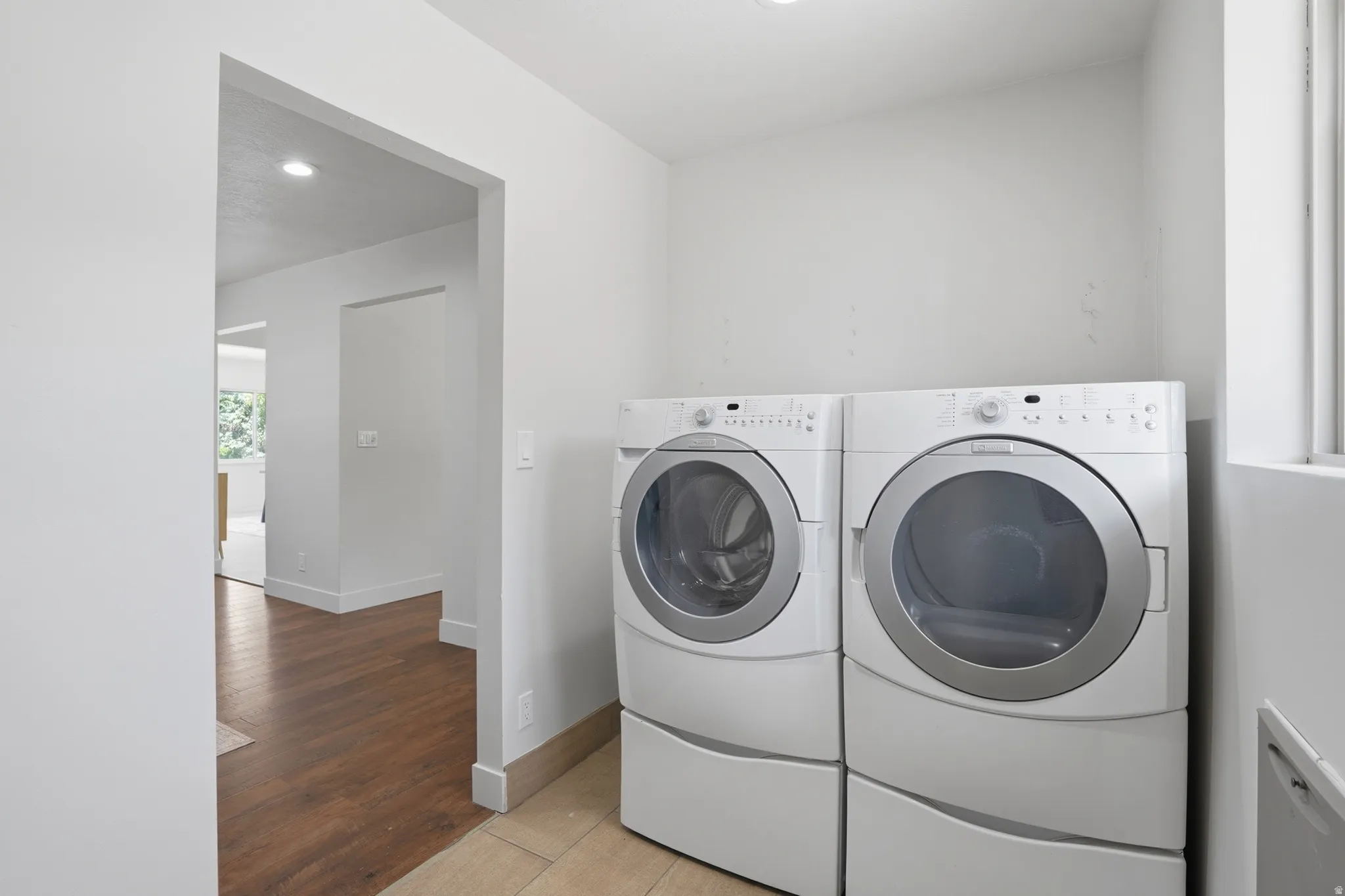 Dedicated laundry area featuring tile flooring, and recessed lighting