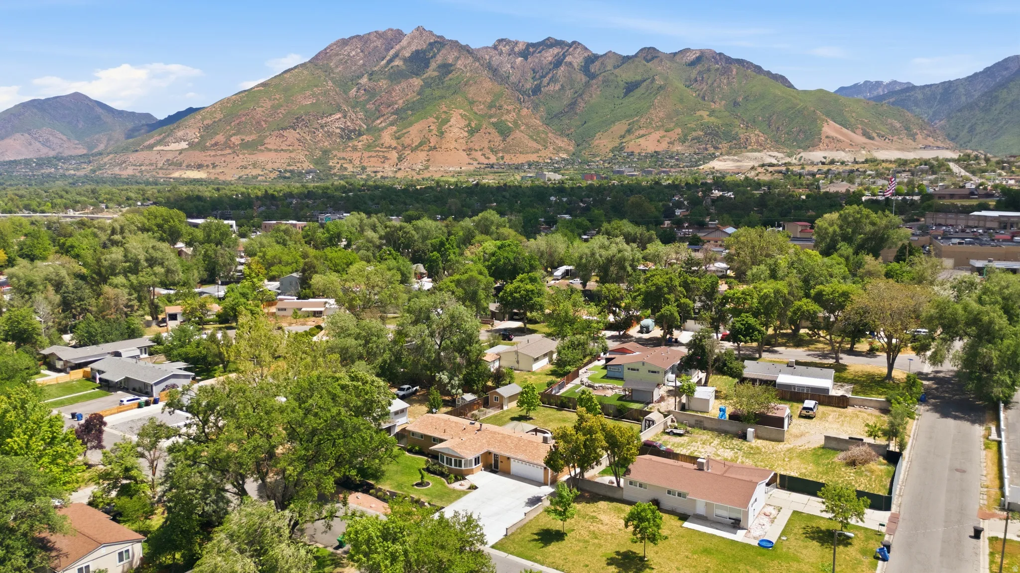 Expansive mountain backdrop overlooking a residential neighborhood with mature trees