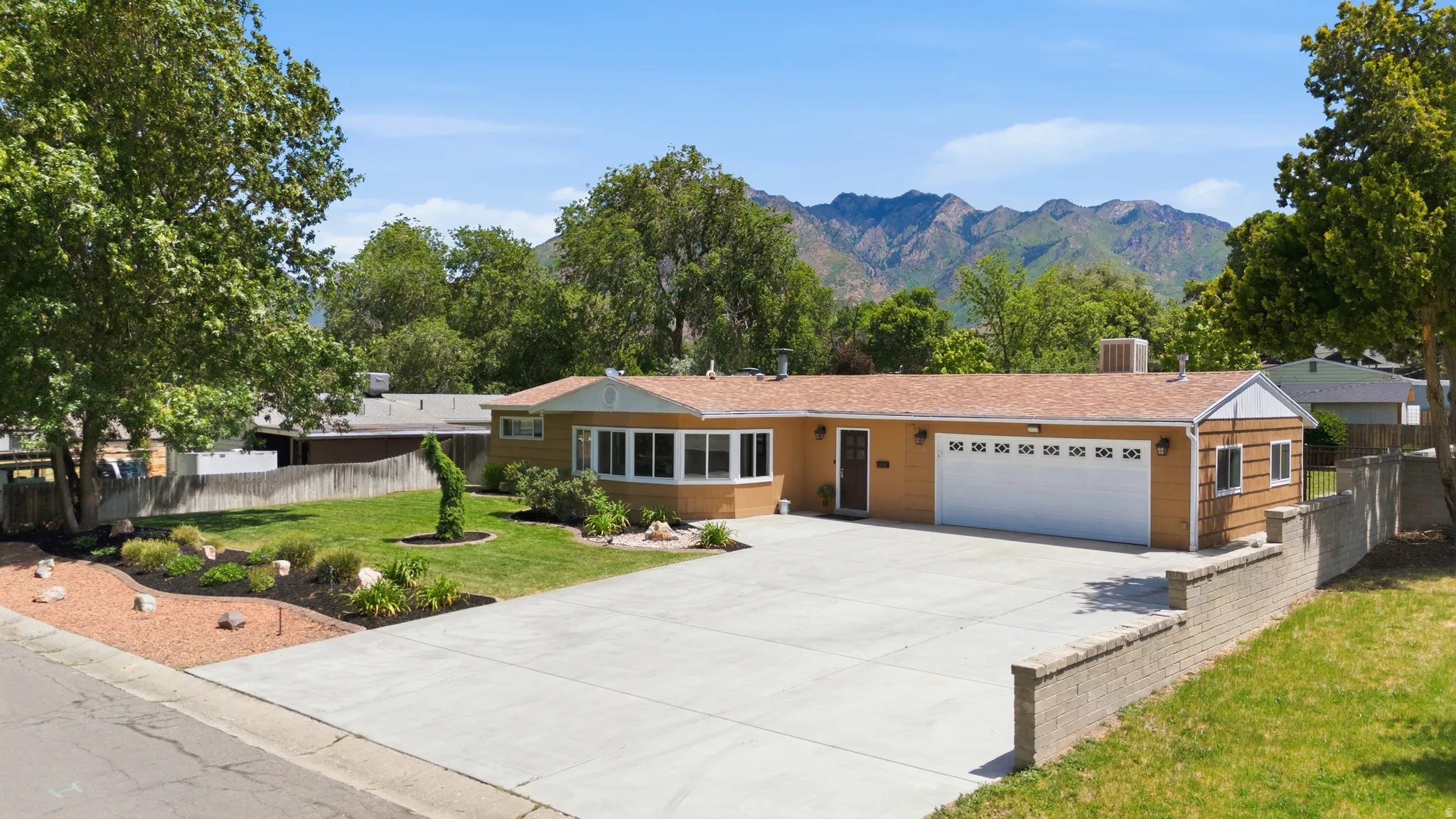 Ranch-style residence featuring a prominent two-car garage and RV hookup area with sewer cleanout