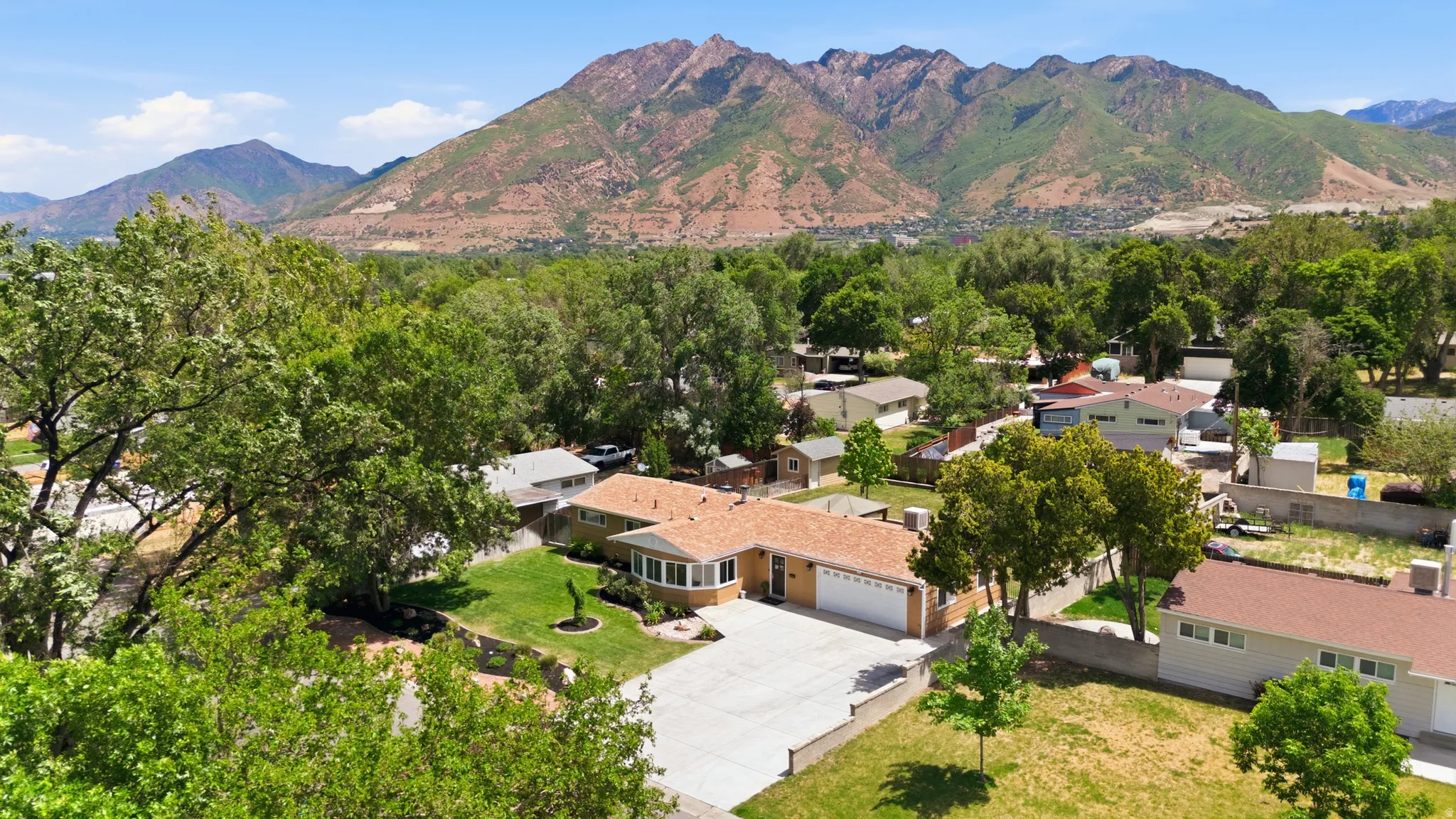 Ranch-style residence featuring a prominent bay window, attached two-car garage, and a concrete driveway