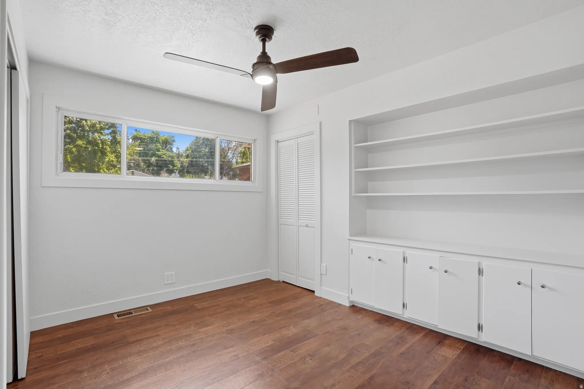 Bedroom 1 with built-in shelving with lower cabinetry