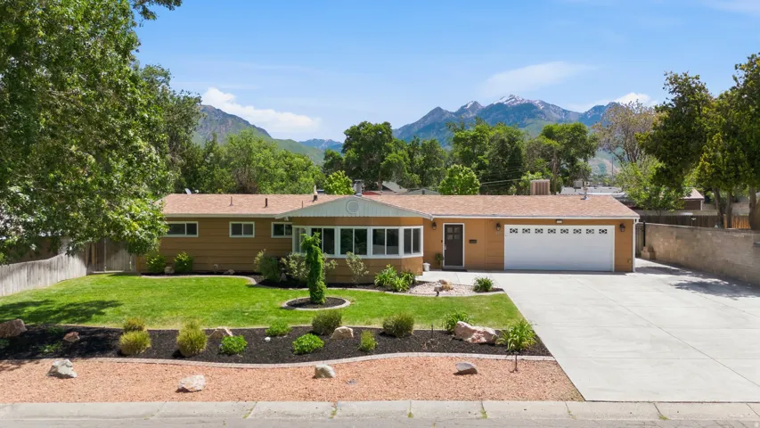 Ranch-style residence featuring a prominent front lawn with established landscaping