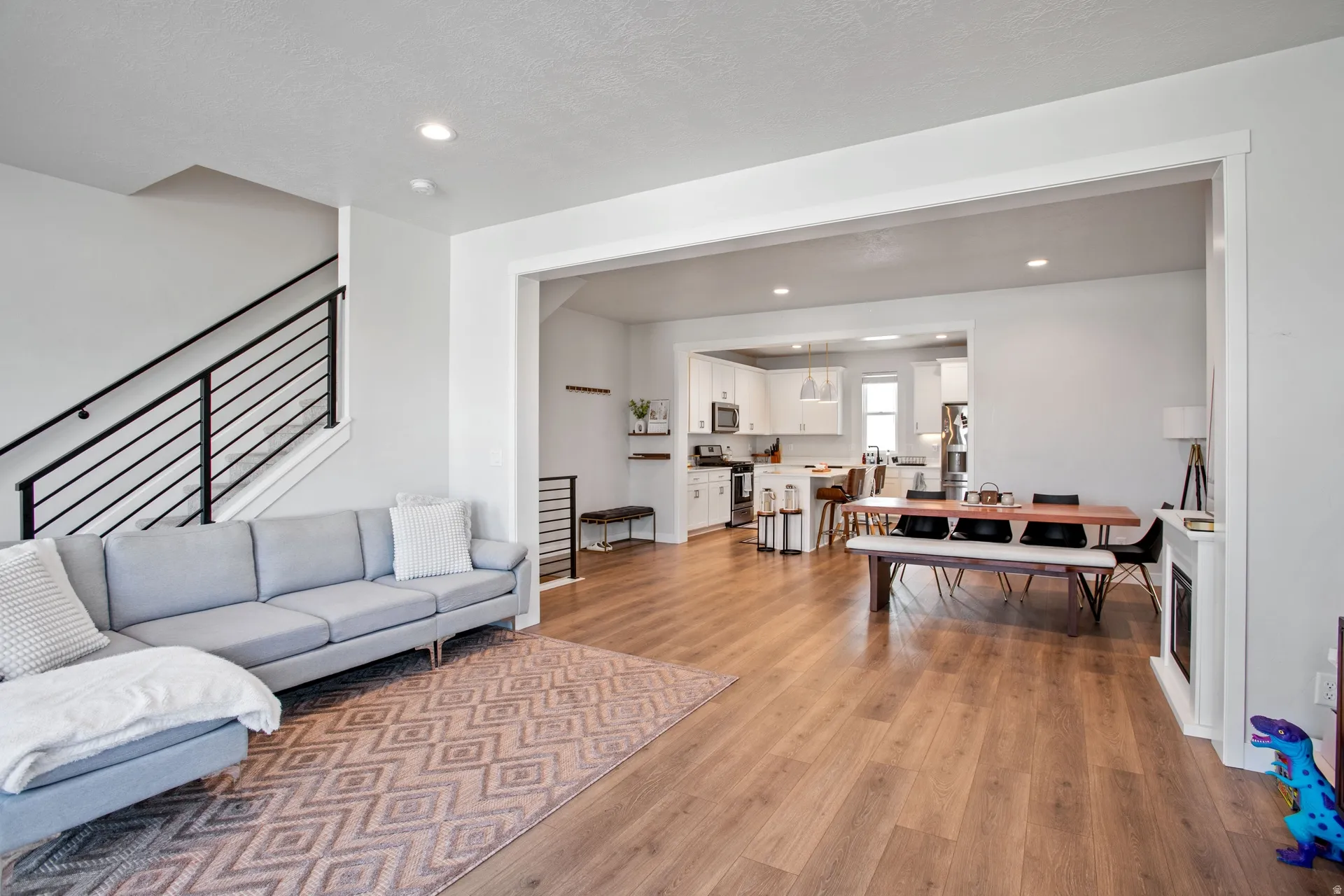 Bright interior featuring wide plank wood-finish flooring throughout the main level