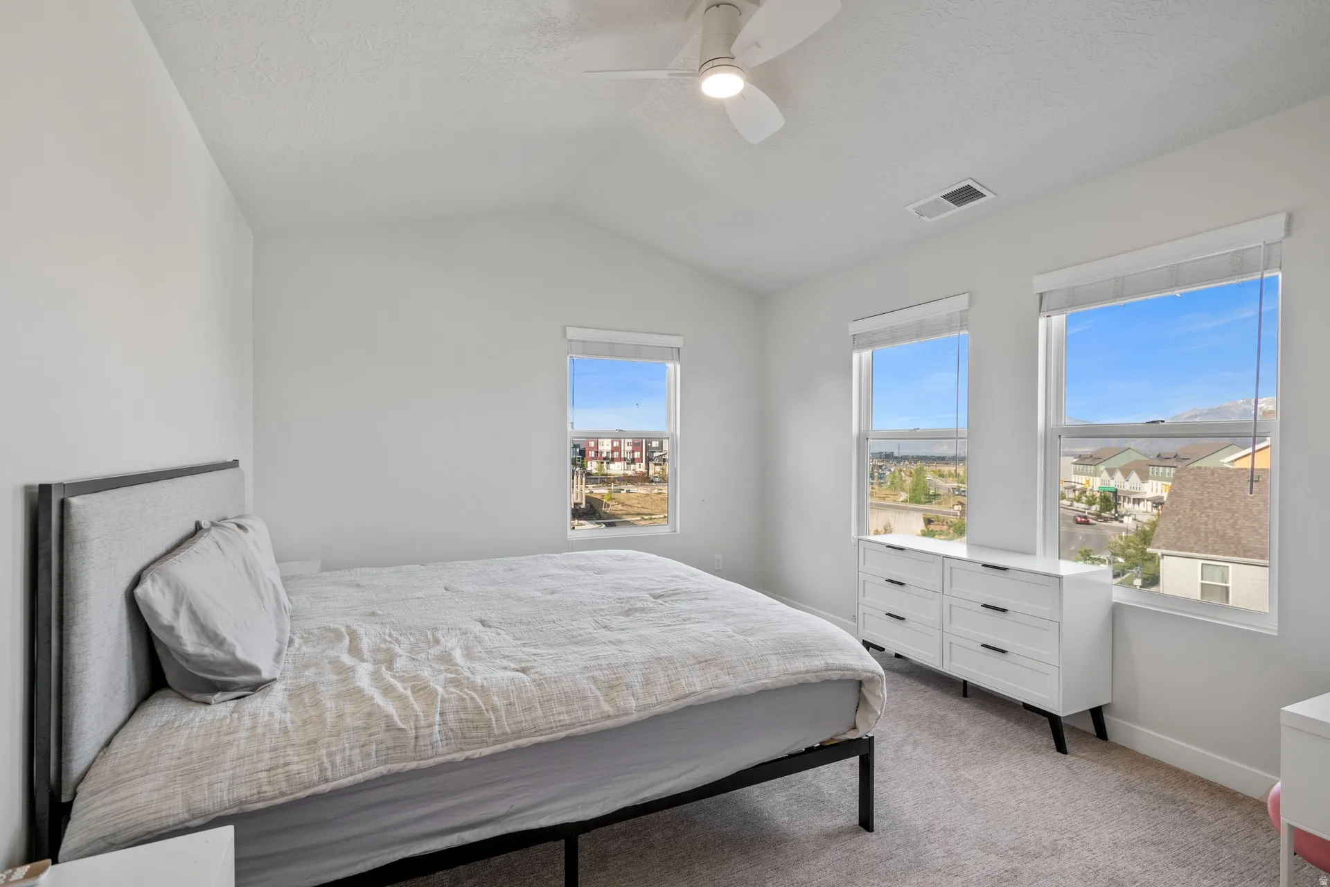 Vaulted ceiling bedroom with a ceiling fan light fixture