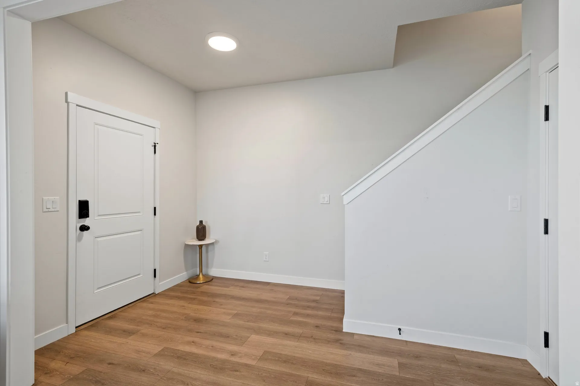 Light wood-finish flooring with crisp white baseboards and trim