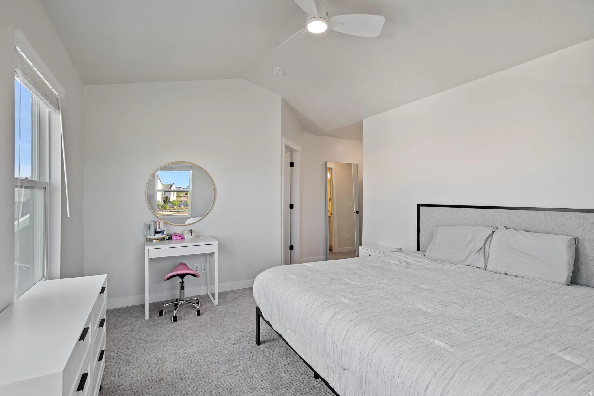 Carpeted bedroom featuring white walls, a ceiling fan, and a window with blinds
