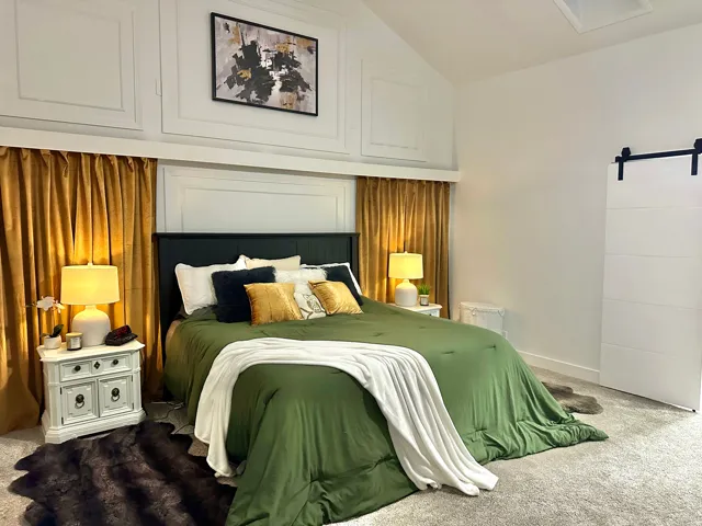 Vaulted ceiling bedroom featuring wainscoting, a sliding barn door, and carpet flooring